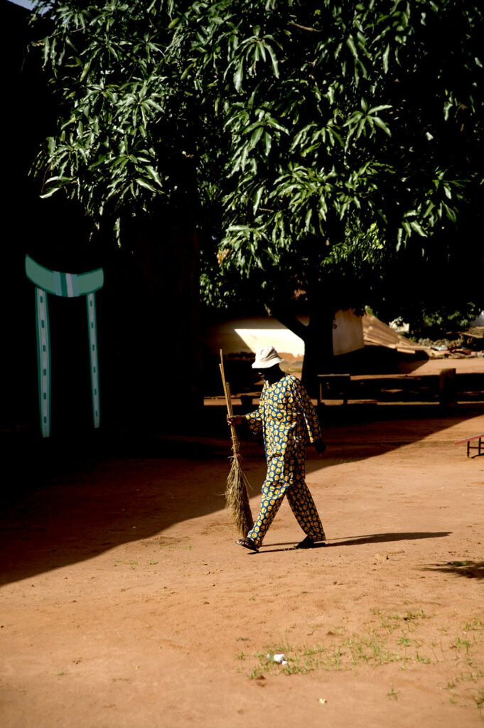 Un homme nettoie la cour dans les Palais royaux d’Abomey. Dahomey. Bénin. François Guibilato photographe.