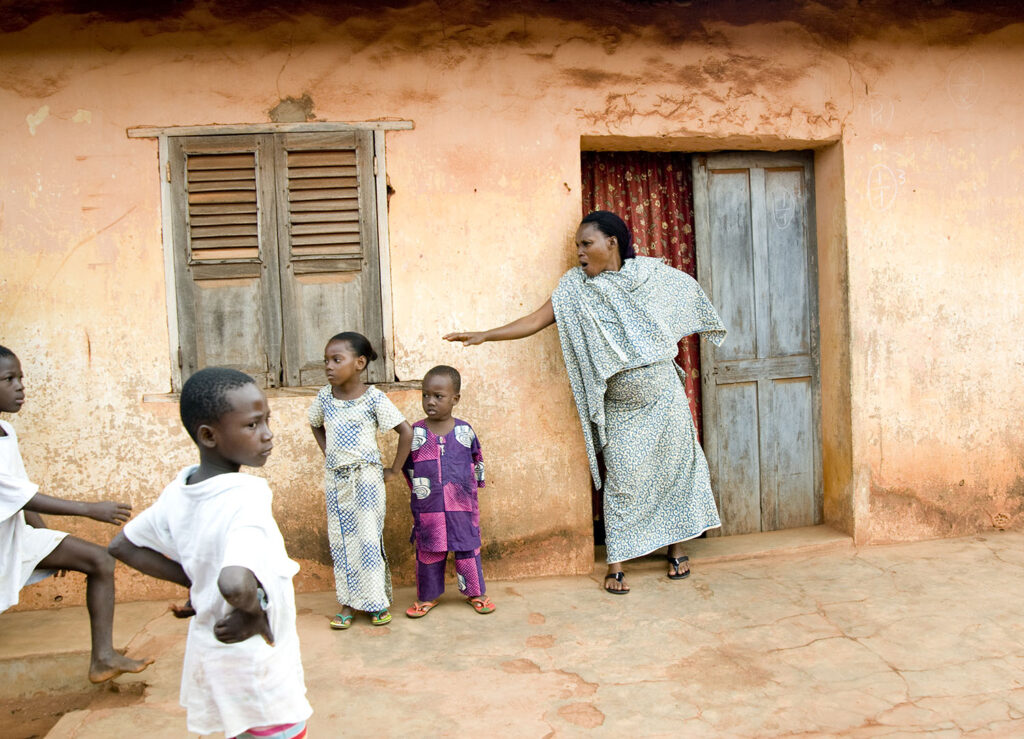 Une mère appelle ses enfants devant sa maison. Scène de rue. Street photographie. Bénin. François Guibilato photographe.