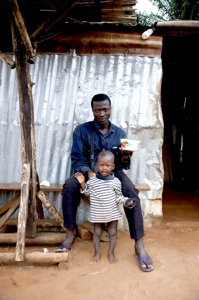 Un père et son fils nous regardent. Scène de rue. Street photographie. Bénin. Abomey. François Guibilato photographe.