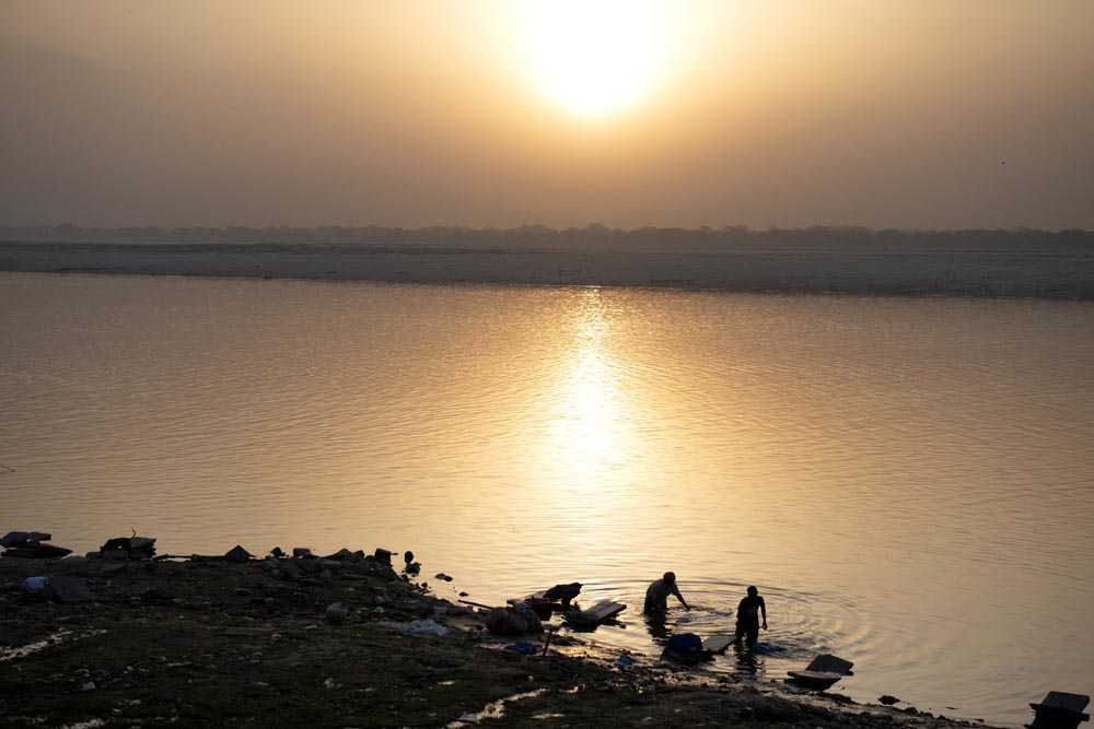 Deux hommes lavent leur linge. Rivière Gange. Lever de soleil. Couleurs. Varanasi. François Guibilato Photographe.