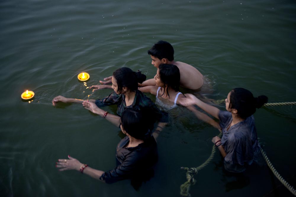 Une famille fait des offrandes. Bougies. Rivière Gange. Couleurs. Bénarès. Varanasi. François Guibilato Photographe.