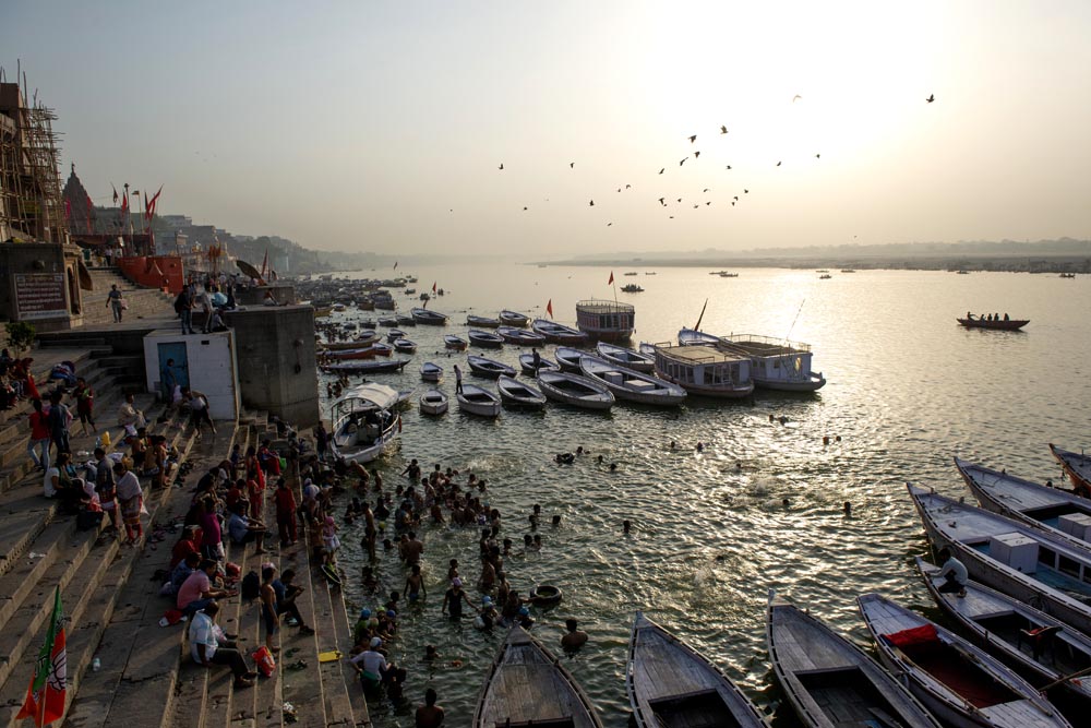 Vue de haut sur la rivière Gange et les ghats de Varanasi. Foule. Bains dans le Gange. Barques. Lever de soleil. Couleurs. Varanasi. François Guibilato Photographe.