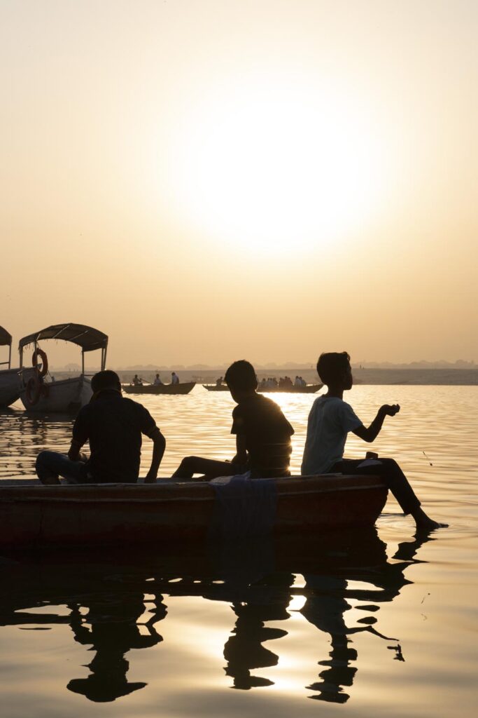 Scène de rue. Street photographie. Des enfants pêchent dans la rivière Gange. Contre jour. Couleurs. Bénarès. Varanasi. François Guibilato Photographe.