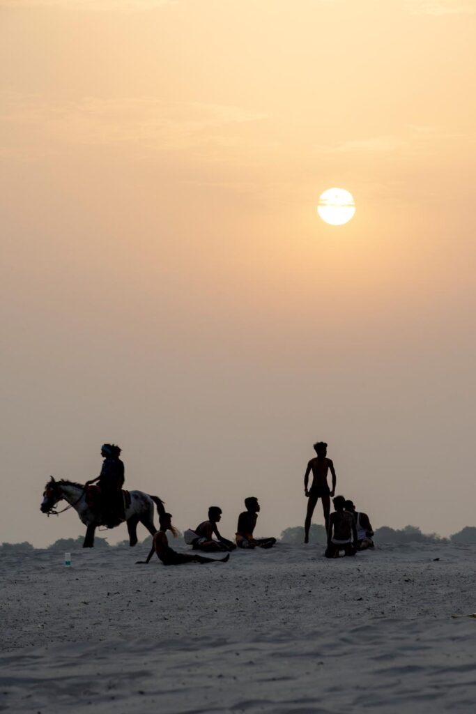 Scène de rue. Street photographie. Des jeunes attendent. Un cheval est sur la gauche de l’image. Couleurs. Bénarès. Varanasi. Lever de soleil. François Guibilato Photographe.