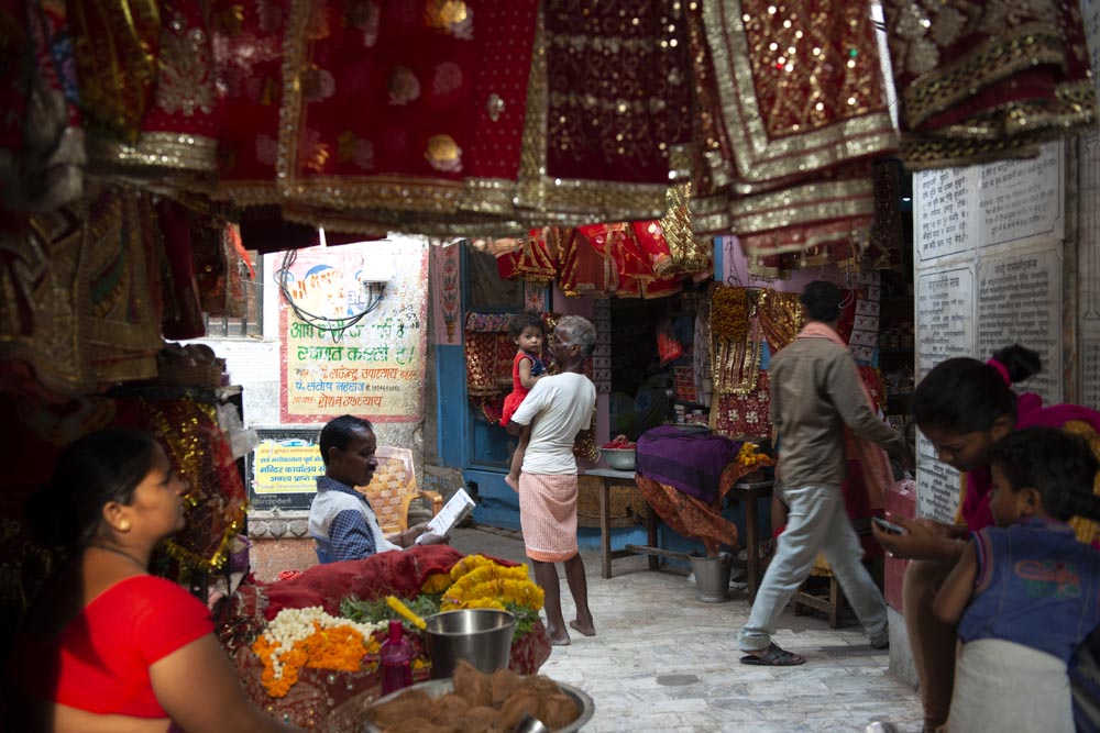 Scène de rue. Street photographie. Un enfant, au centre de la photo, nous regarde. Couleurs. Bénarès. Varanasi. François Guibilato Photographe.