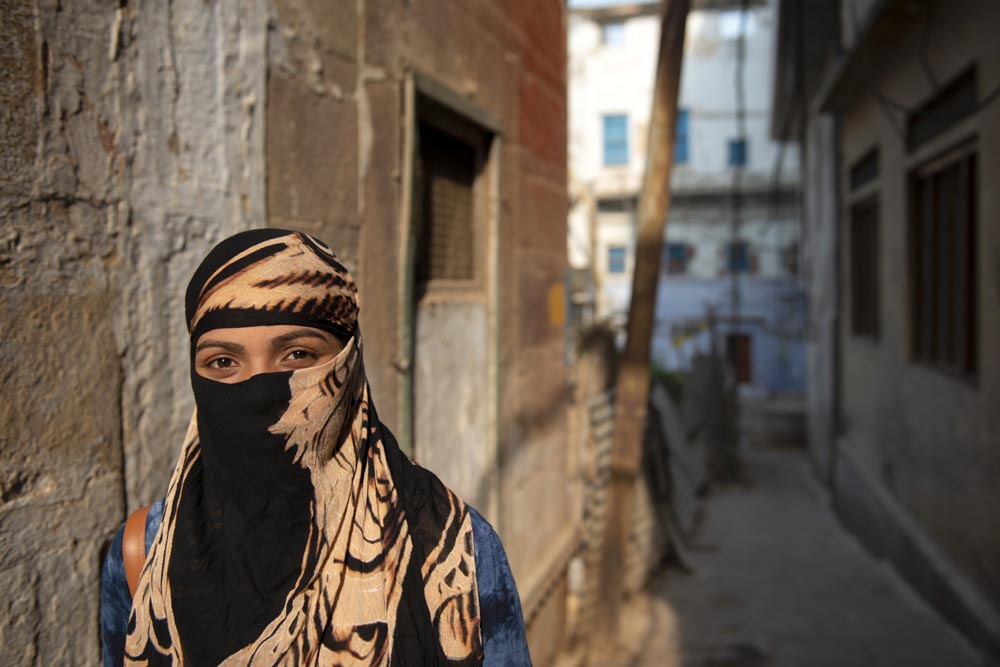 Scène de rue. Street photographie. Une femme nous regarde. Couleurs. Lever de soleil. Bénarès. Varanasi. François Guibilato Photographe.